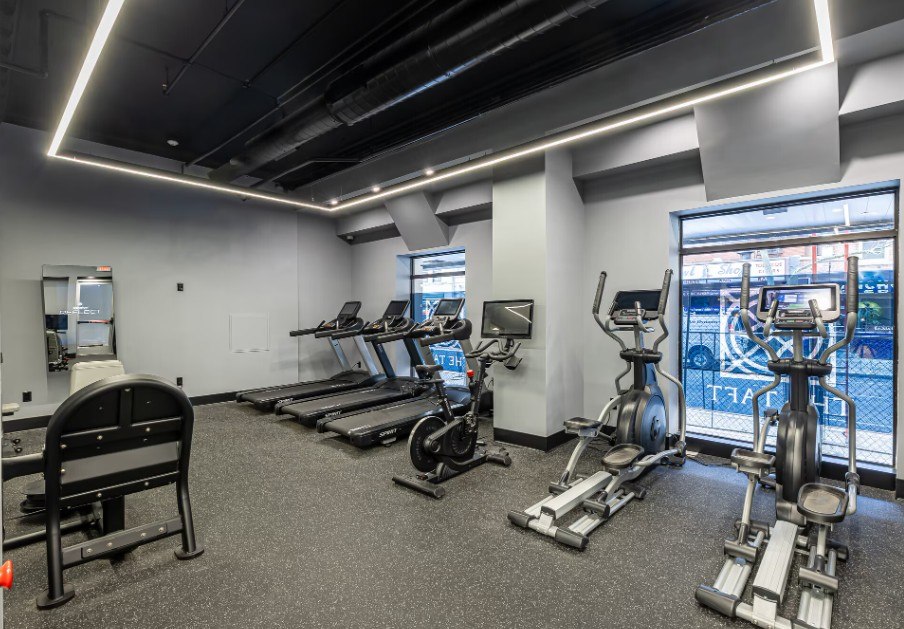 A gym with treadmills, exercise bikes, and a rowing machine.